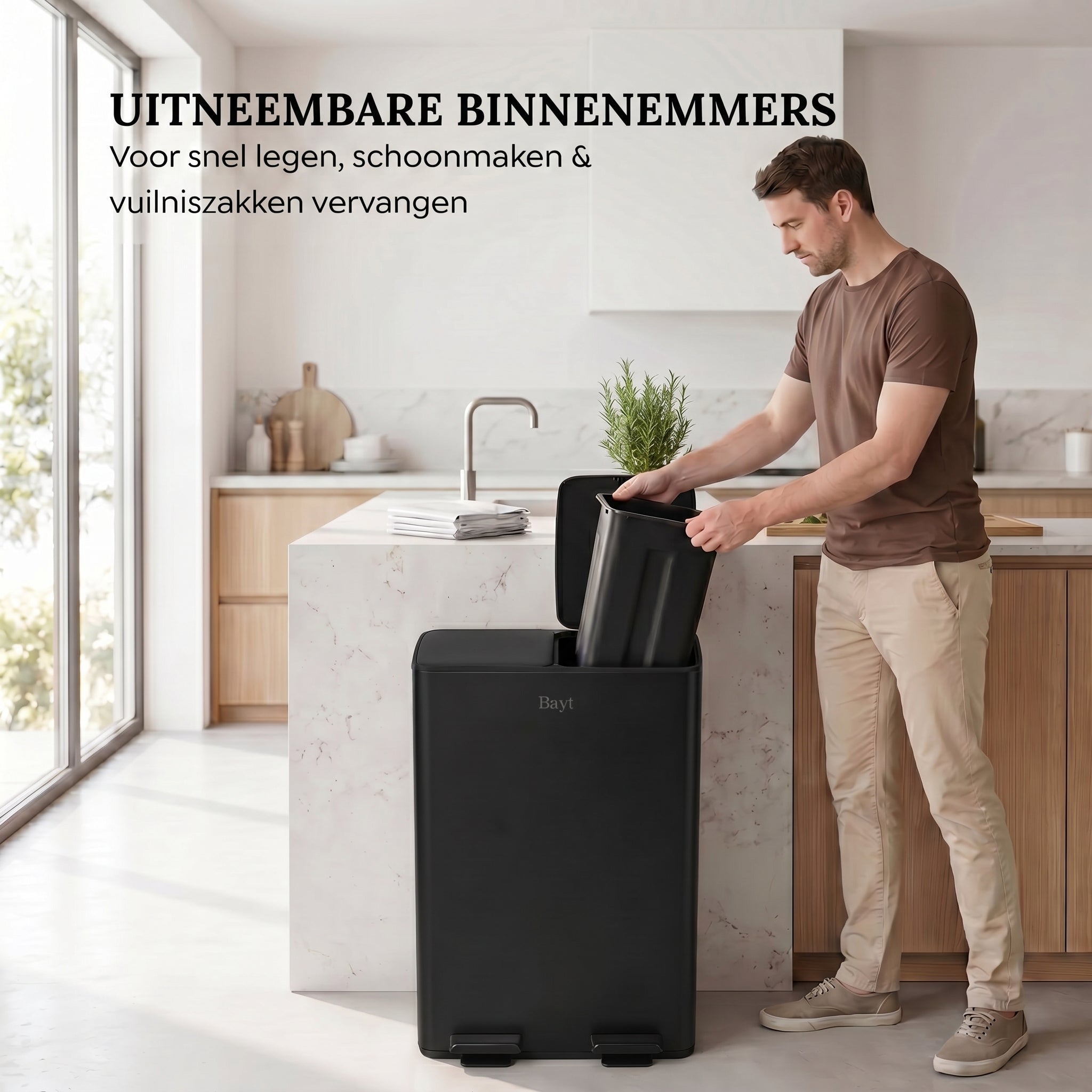Man tilt uitneembare binnenemmer uit Bayt pedaalprullenbak met 2 vakken van 30 liter in zwart voor eenvoudig legen in een moderne keuken