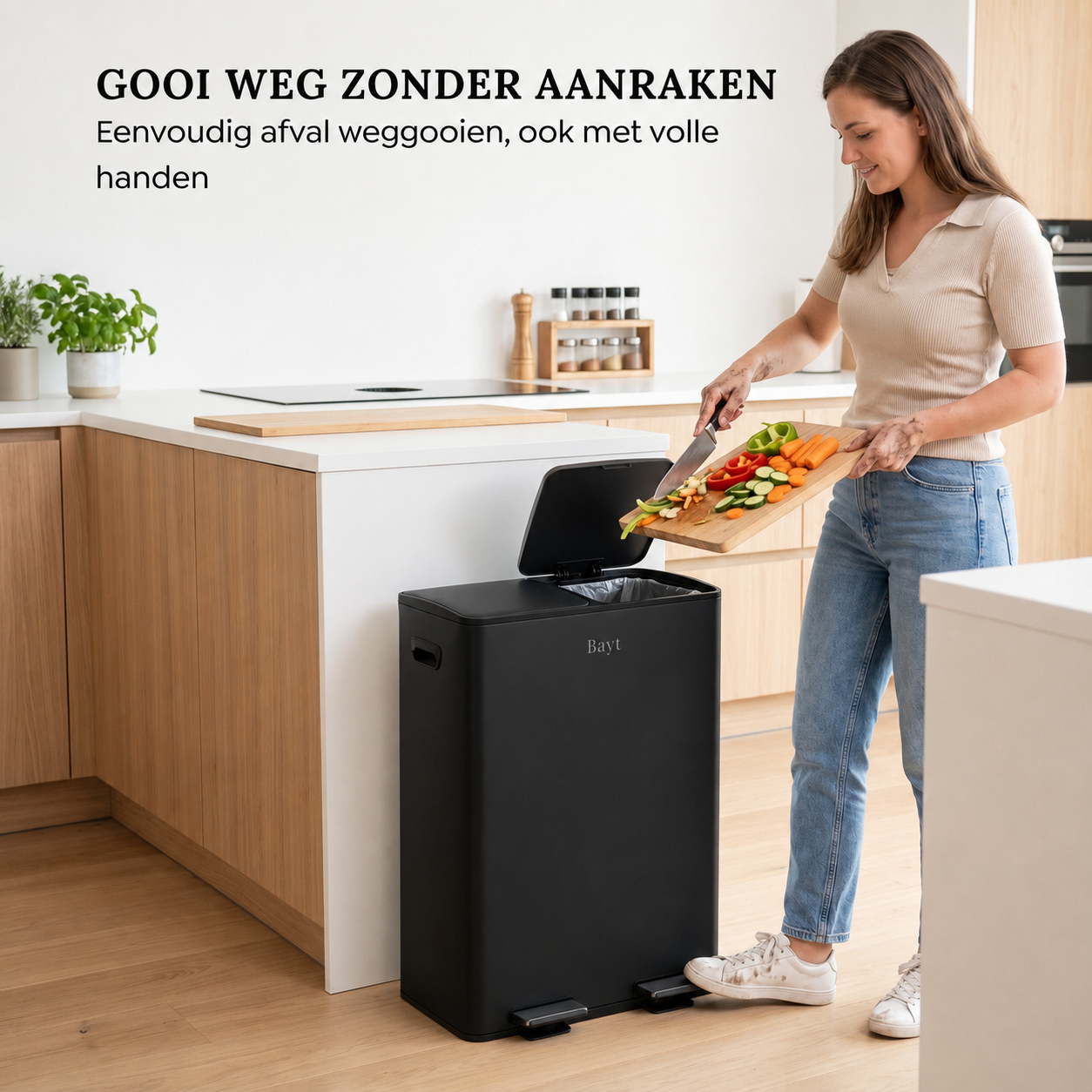 Vrouw gooit groenteafval handsfree weg in een zwarte Bayt pedaalemmer van 60 liter in een moderne keuken.