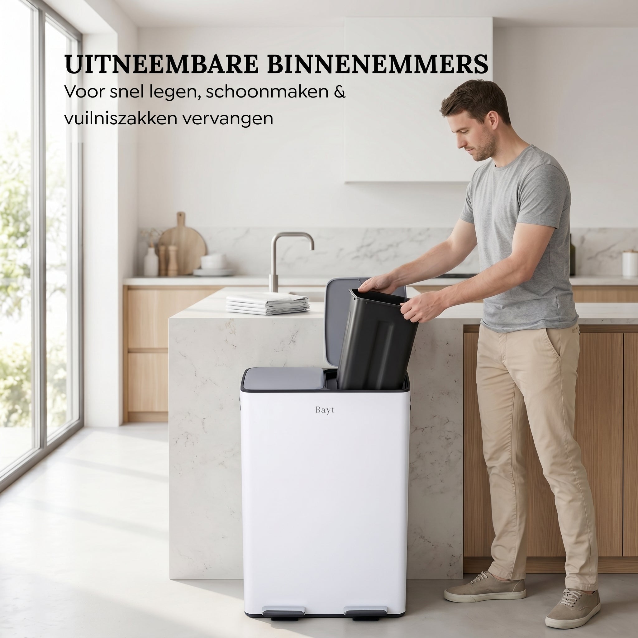 Man tilt uitneembare binnenemmer uit Bayt pedaalprullenbak met 2 vakken van 60 liter in wit voor eenvoudig legen in een moderne keuken